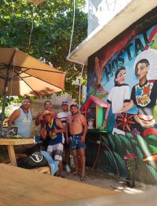 a group of men standing in front of a food stand at Hostal Ledeztrus in Zipolite