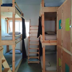 a room with three bunk beds and a ladder at Hostal Ledeztrus in Zipolite
