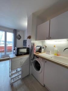 a kitchen with a washing machine and a microwave at Escapade Romantique- Vue Port et Balcon Ensoleillé in Dives-sur-Mer +29 photos
