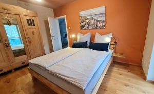 a bedroom with a large bed with orange walls at Apartment Niesenpoint in Albersdorf
