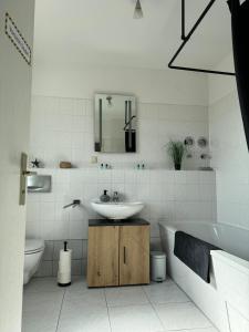a bathroom with a sink and a tub and a toilet at Zentrale Lage - 2 Einzelbetten - Waschmaschine - Badewanne - WLAN - Netflix - 5min zum Bahnhof in Zwickau