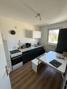 a small kitchen with a table and a counter top at Zentrale Lage - 2 Einzelbetten - Waschmaschine - Badewanne - WLAN - Netflix - 5min zum Bahnhof in Zwickau