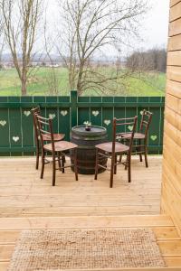 eine Terrasse mit einem Tisch, Stühlen und einem Zaun in der Unterkunft Apartmaji Babi in Markovci
