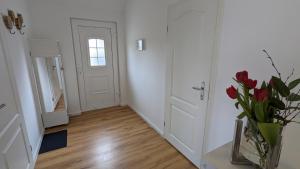 a hallway with a vase of flowers and a door at FeWo Catalina in Westerstede