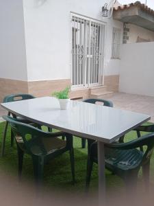 a white table and chairs in a yard at Casa en Jerez con patio cerca de la playa y de la sierra in Jerez de la Frontera