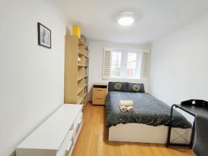 a small bedroom with a bed and a book shelf at Spacious 3-Bed Cosy Flat in Westminster in London