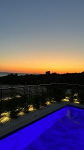 une piscine avec vue sur le coucher du soleil en arrière-plan dans l'établissement Apartment “InBlue” with private pool, à Kožino