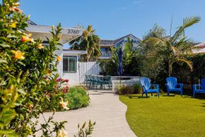 a patio with blue chairs and a table in a yard at Charming Beach Bungalows - 4BR, Sleeps 10, Pets OK in Carlsbad