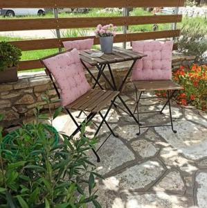 2 sillas y una mesa en el patio en Elia House 3 near Nafpaktos, en Lóngos