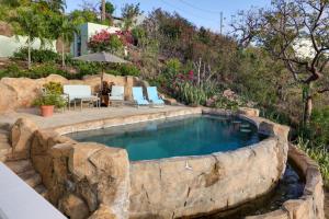 una piscina con una pared de roca alrededor en Sea La Vie about Waterfront St Thomas Escape with Pool en Nazareth