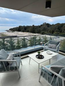 d'un balcon avec des chaises et une table offrant une vue sur l'océan. dans l'établissement Apartment “InBlue” with private pool, à Kožino