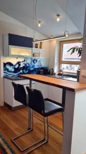 a kitchen with a table and two black chairs at Apartment Niesenpoint in Albersdorf