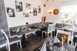 ein Esszimmer mit Tischen und Stühlen in einem Restaurant in der Unterkunft Hotel Apartments Restaurant CALA LUNA in Marburg an der Lahn