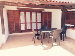 a dining table and chairs in a room with windows at Appartamento centralissimo in San Teodoro in San Teodoro +20 photos