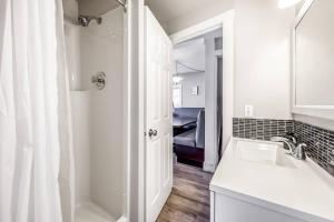 a white bathroom with a sink and a shower at Secluded Cabin On The Lake #7 in West Kelowna