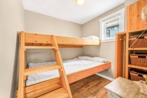 a bedroom with two bunk beds and a window at Secluded Cabin On The Lake #7 in West Kelowna