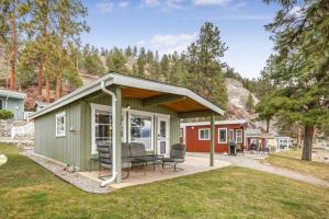a green tiny house with a porch at Secluded Cabin On The Lake #7 in West Kelowna