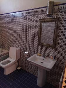 La salle de bains est pourvue d'un lavabo, de toilettes et d'un miroir. dans l'établissement Family villa with swimming pool and a wonderful mountain view, à Marrakech