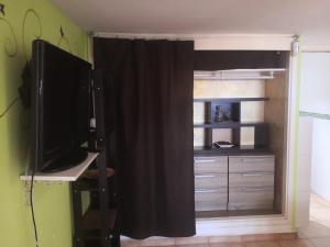 uma sala com um quarto com uma cama e uma televisão em finca Lotusflower em Aguatona
