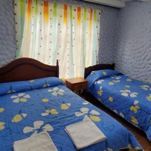 a bedroom with two beds with towels on them at El Colibrí Azul in Quito
