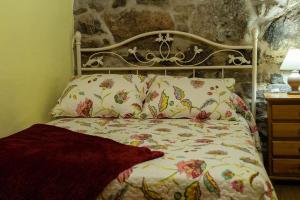 een slaapkamer met een bed met een bloemenbed bij Casa El Mirador del Miño en la Ribeira Sacra in Rosende