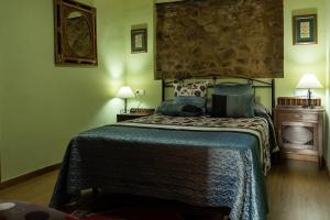 een slaapkamer met een bed met een blauw dekbed bij Casa El Mirador del Miño en la Ribeira Sacra in Rosende