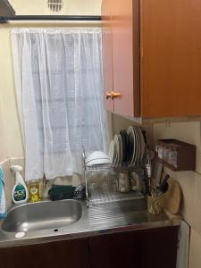 um balcão de cozinha com um lavatório e uma janela em Ample Residence em Nairobi