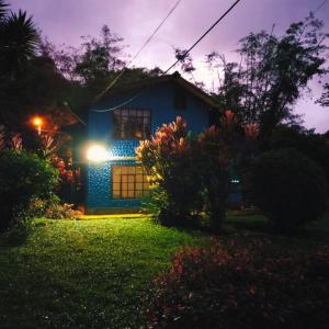 una casa azul con una luz encendida por la noche en El Colibrí Azul en Quito