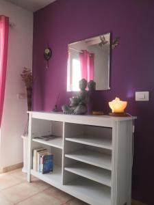 a white shelf with a mirror on a purple wall at Flor de Loto -Finquita Lotusflower in Aguatona