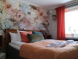 a bedroom with a large bed with a floral wall at Lustigsgården Boutique Hotel in Rättvik