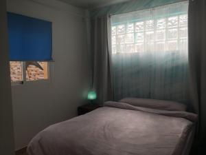 um quarto com uma cama ao lado de uma janela em finca Lotusflower em Aguatona