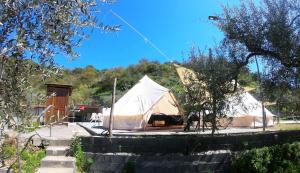 une grande tente dans un champ avec un bâtiment dans l'établissement Gole Alcantara mini Campeggio privato, à Motta Camastra