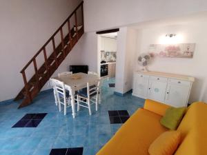 a living room with a yellow couch and a table at Appartamento centralissimo in San Teodoro in San Teodoro