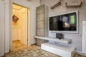 uma sala de estar com uma televisão na parede em B&B Corsini em Bolonha