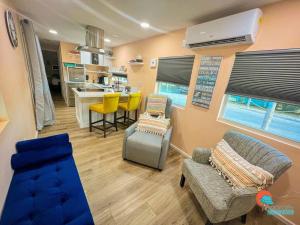 a living room with a couch and chairs and a kitchen at Pinecraft Sunset Tiny Home in Sarasota