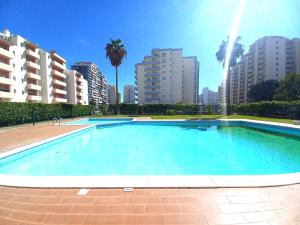 uma grande piscina numa cidade com edifícios altos em Pink Beach Apartment 223 em Portimão
