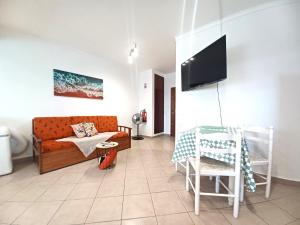 uma sala de estar com uma cama e uma televisão em Pink Beach Apartment 223 em Portimão