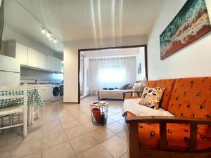 uma sala de estar com um sofá e uma cozinha em Pink Beach Apartment 223 em Portimão