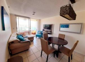 a living room with a couch and a table and chairs at Condominio Don Lorenzo in Coquimbo
