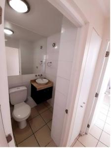 a white bathroom with a toilet and a sink at Condominio Don Lorenzo in Coquimbo