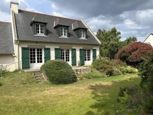 een wit huis met groene rand op een erf bij 611 - Maison 9 couchages, proche du Cap d'Erquy in Erquy