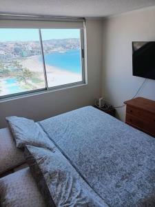 a bedroom with a bed and a large window at Condominio Don Lorenzo in Coquimbo
