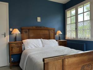 een slaapkamer met een groot bed met blauwe muren en ramen bij 611 - Maison 9 couchages, proche du Cap d'Erquy in Erquy