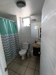a bathroom with a toilet and a sink at Condominio Don Lorenzo in Coquimbo