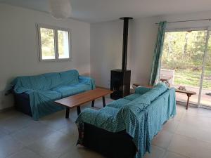 uma sala de estar com dois sofás azuis e uma mesa em Maison bord de mer - la Tranche sur mer em La Tranche-sur-Mer
