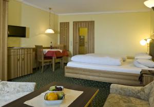 ein Hotelzimmer mit einem Bett und einem Tisch in der Unterkunft Bad Füssing Appartementhof Aichmühle in Bad Füssing