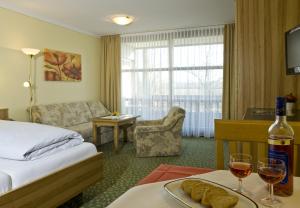 une chambre d'hôtel avec un lit et une table avec des verres à vin dans l'établissement Bad Füssing Appartementhof Aichmühle, à Bad Füssing