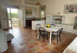 a kitchen with a table and chairs in a room at Villetta Greco - Torre Lapillo in Porto Cesareo