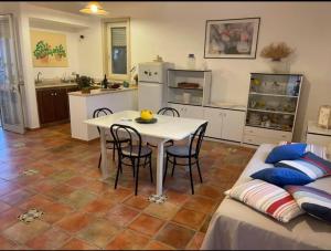 a kitchen and living room with a table and a couch at Villetta Greco - Torre Lapillo in Porto Cesareo