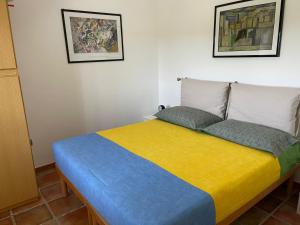 a bedroom with a bed with a yellow and blue blanket at Villetta Greco - Torre Lapillo in Porto Cesareo